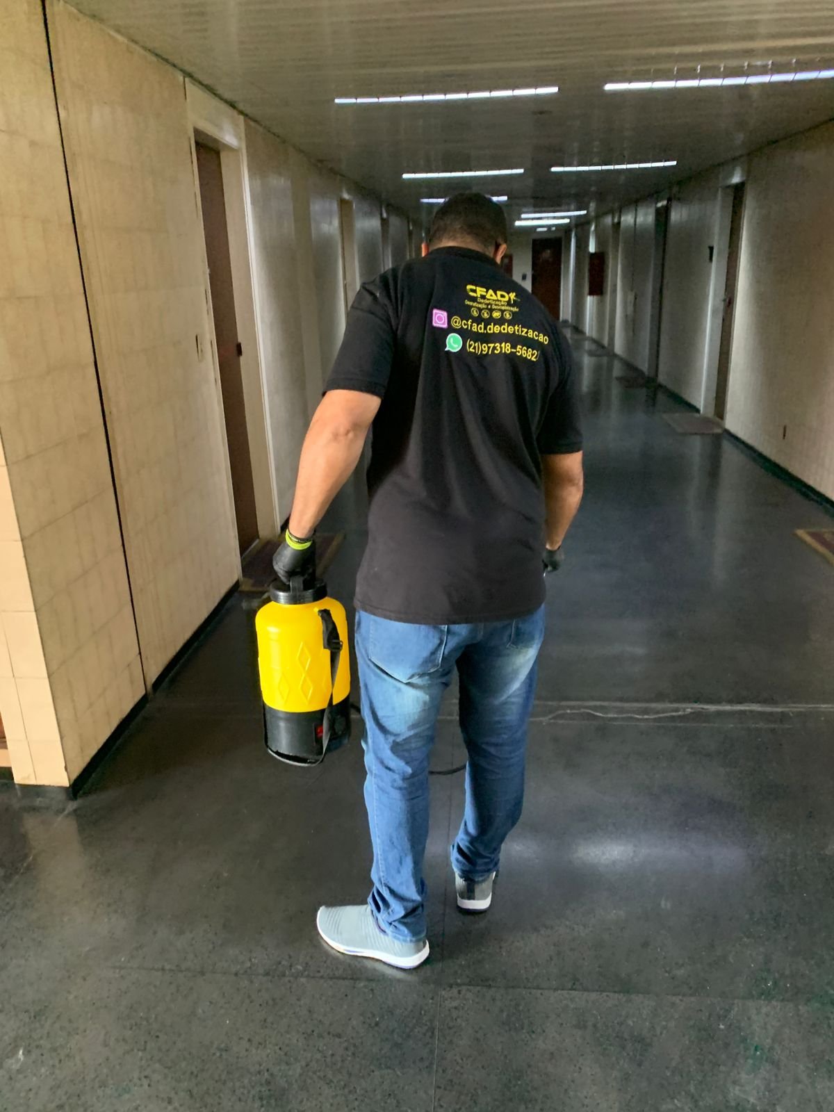 Técnico da CFAD levando equipamento para atendimento em área comum de edifício